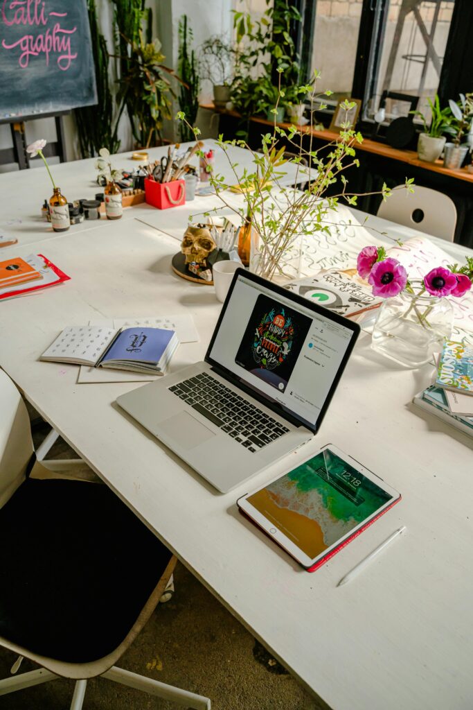 Stylish indoor workspace with technology, books, and vibrant plants.